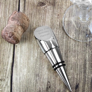 May include: Silver bottle stopper with a black rubber seal. The stopper is engraved with the text "Happy 21st Birthday Hannah".