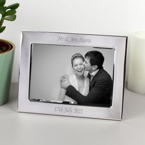 May include: Silver photo frame with a black and white photo of a couple. The frame is engraved with "Mr & Mrs Harris" and "17th July 2021".