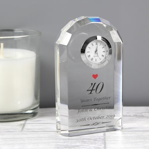 May include: A clear crystal clock with a red heart and the inscription "40 Years Together John & Christine 30th October 2019".