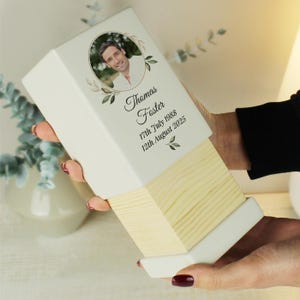 May include: White wooden box with a photo of a man and the text "Thomas Foster 17th July 1988 12th August 2025".