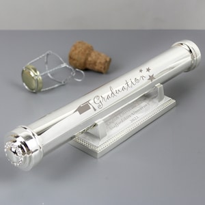 May include: Silver graduation certificate holder with a silver stand. The holder is engraved with the text "Graduation", a graduation cap, and two stars. The stand is engraved with the text "Sophie Brown, English Literature 2021, Staffordshire University 2021".