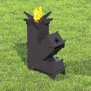 May include: A black metal camping stove with a fire burning inside. The stove has a rectangular body with a chimney and a hinged door. The top of the stove has a star-shaped design. The stove is sitting on green grass.