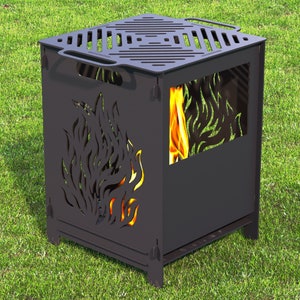 Könnte beinhalten: Ein schwarzer Metall-Feuerkorb mit quadratischem Design, Flammen-Ausschnitten an den Seiten und einer geschlitzten Oberseite. Der Feuerkorb hat an jeder Seite einen Griff und steht auf grünem Gras. Flammen sind im Inneren sichtbar.