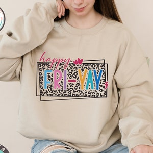 May include: A beige sweatshirt with the text "happy FRI-YAY" in colorful letters on a leopard print background.