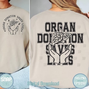 May include: A cream-coloured sweatshirt with the words "ORGAN DONATION SAVES LIVES" in black. The design features a liver graphic held by hands. The back of the sweatshirt also has the same text and graphic.
