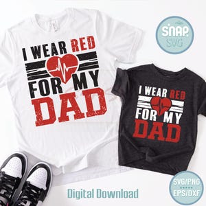 May include: Two t-shirts, one white and one dark gray, with the text "I WEAR RED FOR MY DAD" in red and black. A red heart with a heartbeat line is in the center. The shirts are displayed with a pair of black and white sneakers.