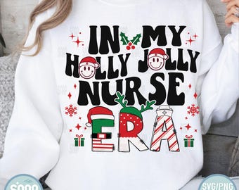 May include: White sweatshirt with a Christmas-themed design that says "In My Holly Jolly Nurse Era". The design features a Santa hat, reindeer antlers, and a candy cane.