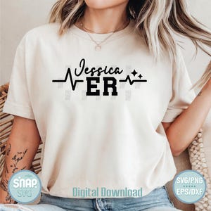 K&ouml;nnte beinhalten: Ein wei&szlig;es T-Shirt mit einem schwarzen Grafikdesign, auf dem "Jessica ER" mit einer Herzschlaglinie und zwei Sternen steht. Die Grafik ist mittig auf dem Shirt platziert.