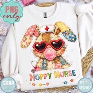 May include: White sweatshirt featuring a patchwork bunny wearing heart-shaped sunglasses and a nurse's hat. The bunny has a pink bubblegum bubble and a stethoscope. The text "HOPPY NURSE" is below the bunny.