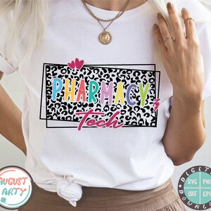 May include: White t-shirt with a black and white leopard print design. The text "Pharmacy Tech" is written in rainbow colors on the shirt.