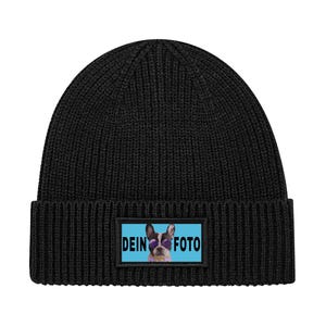 Puede incluir: Gorro negro de punto con un parche rectangular que muestra un perro con gafas de sol y las palabras "DEIN FOTO" en blanco. El gorro está hecho de punto acanalado.