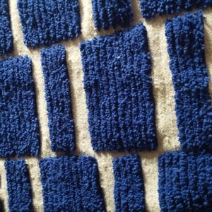 Blue and white Moroccan hand-knotted wool rug with a geometric grid of blue blocks on white, placed on tiled floor.