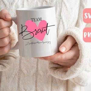 May include: White ceramic mug with a pink heart and black text that reads "Team Braut" and "Zweitbeste Freundin der Braut".
