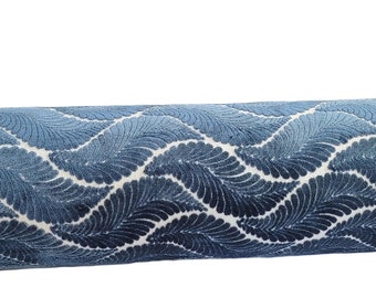May include: A blue and white patterned cylindrical pillow with a wave-like design.