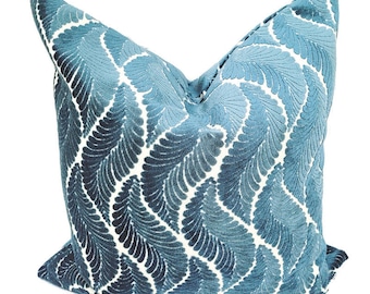 May include: A blue velvet throw pillow with a white feather pattern.