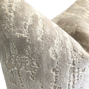 May include: A close-up of a gray and white patterned throw pillow with a soft, textured fabric.