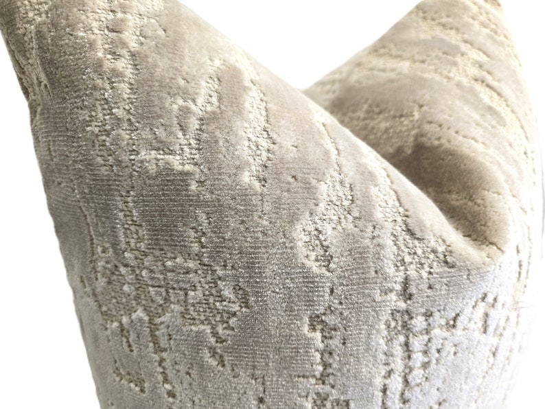 May include: A close-up of a gray and white patterned throw pillow with a soft, textured fabric.