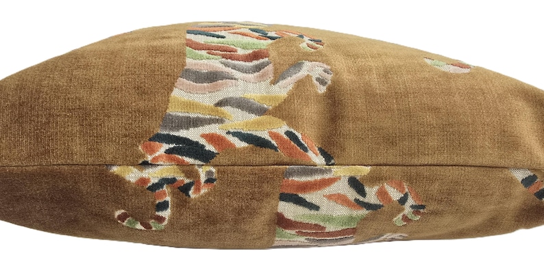 Peut inclure: Un coussin de d&eacute;coration brun avec un motif de tigre color&eacute;. Le tigre est repr&eacute;sent&eacute; en train de bondir, ses rayures et ses taches sont visibles.