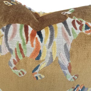 Peut inclure: Un coussin en velours marron avec un motif de tigre brod&eacute; color&eacute;. Le tigre est ray&eacute; de nuances de rose, jaune, vert, orange et bleu.