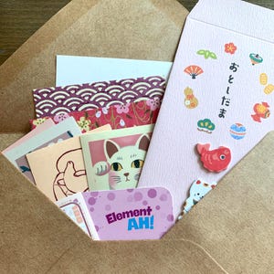 Lucky cat stationery mystery bundle partially opened pochi envelope with cat stickers and Japanese paper goods peeking out