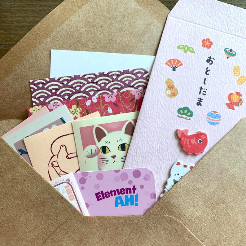 Lucky cat stationery mystery bundle partially opened pochi envelope with cat stickers and Japanese paper goods peeking out