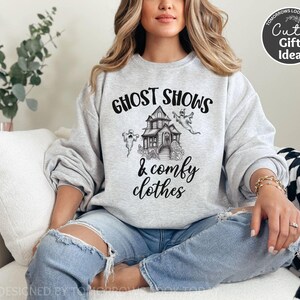 May include: A gray sweatshirt with the text "Ghost Shows & Comfy Clothes" and a black and white illustration of a haunted house with ghosts.