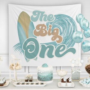 Op de afbeelding: Een feestsc&egrave;ne met een witte achtergrond met een surfboard- en golfontwerp, met de tekst "The Big One". De sc&egrave;ne omvat blauwe ballonnen, een taart, cupcakes en diverse snoepjes, wat een feestelijke sfeer cre&euml;ert.