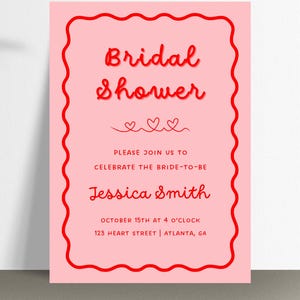 Könnte beinhalten: Rosafarbene Einladung zu einer Brautparty mit rotem Text. Der Text lautet "Bridal Shower", "Please join us to celebrate the bride-to-be Jessica Smith", "October 15th at 4 o'clock", und "123 Heart Street | Atlanta, GA".