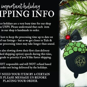 May include: Black and green cauldron Christmas ornament with a pentagram and the text "Winter Solstice 2021" and "The One, The Only". The ornament is hanging from a black and red bow on a white furry surface. The text "Salem Supply Co." is in the bottom right corner.