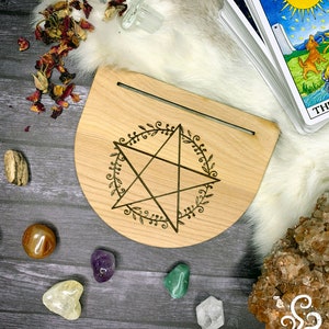 May include: A wooden pentagram altar with a five-pointed star and floral design. The altar is surrounded by crystals and tarot cards.