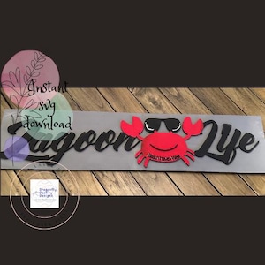 Puede incluir: Un letrero recortado en negro y rojo con el texto "Lagoon Life" y un cangrejo rojo con gafas de sol. El cangrejo tiene el texto "Beach Haven West" en su caparazón.