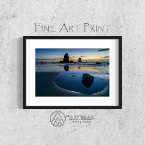 May include: Framed fine art print of a coastal landscape at dusk. The image features a calm ocean reflecting the sky's colors, with rock formations and the text "FINE ART PRINT" at the top. The Artisan Marketplace logo is at the bottom.