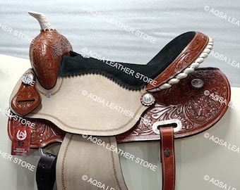 May include: A brown leather saddle with a white and black seat. The saddle has intricate floral designs and silver accents. The saddle is protected with a watermark.
