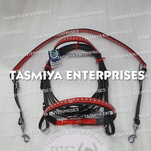 Peut inclure: Bride de cheval noire et rouge avec des accessoires argentés. La bride présente des accents rouges avec des strass décoratifs et est conçue pour l'équitation. L'image affiche également le logo "TASMIYA ENTERPRISES".