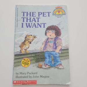 May include: A children's book titled "The Pet That I Want" with a cartoon illustration of a child and a dog. The book cover includes the text "My First Hello Reader!" and "With Flash Cards!" by Mary Packard.