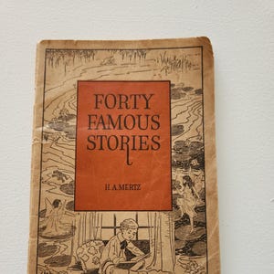 May include: A vintage book titled "Forty Famous Stories" by H.A. Mertz. The cover features a boy reading a book, surrounded by fairies and water lilies.