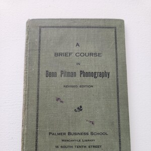 May include: A green book with the title "A Brief Course in Benn Pitman Phonography, Revised Edition" and the text "Palmer Business School, Mercantile Library, 16 South Tenth Street, Philadelphia".
