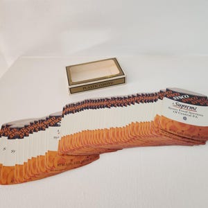 May include: A stack of white plastic-coated cards with orange and black text. The top card reads "Sysco Supreme Sysco Food Services of Central PA".