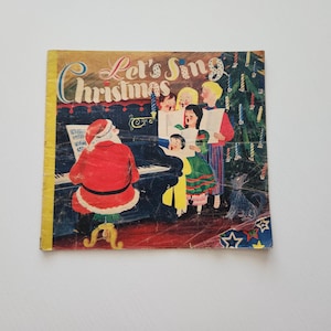 May include: A vintage Christmas-themed book cover with the title "Let's Sing Christmas." The illustration depicts Santa Claus playing a piano while children sing carols. The cover has a yellow spine and a colorful, festive design.