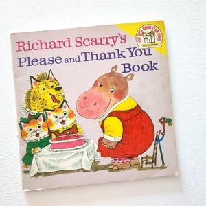 May include: A vintage children's book titled "Richard Scarry's Please and Thank You Book" featuring a pink hippopotamus, a cheetah, and three cats. The book cover is illustrated with a pink and white cake and a small wooden chair.
