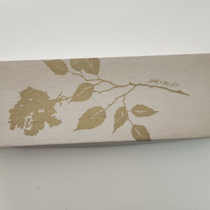 May include: A light beige box with a gold floral design and the text "Lola + Taylor" printed on the top.