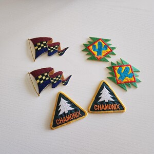 May include: Embroidered patches featuring various designs. Two patches depict waving flags with blue and checkered patterns. Two patches have a cactus design. Two triangular patches with a tree and the word "CHAMONIX" are also present.