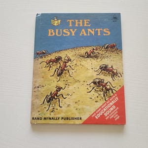 May include: Vintage children's book titled "The Busy Ants" with a blue cover featuring illustrations of ants. The book is published by Rand McNally and includes a red corner label stating it is "Educationally Sound."