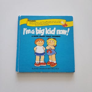 May include: A children's book titled "I'm a big kid now!" with a blue cover. The cover features illustrations of a boy and a girl. The book includes two stories and a section on toilet training. The author is JOAE GRAHAM BROOKS, M.D.