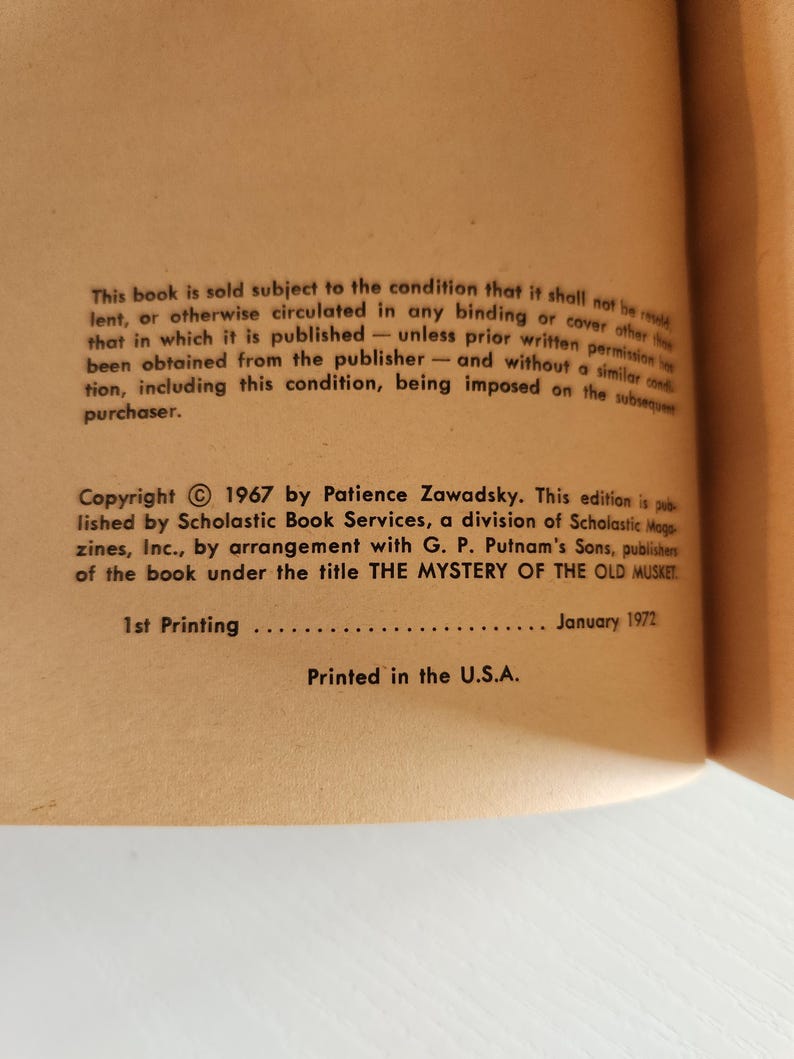 Pode incluir: Um close-up das informa&ccedil;&otilde;es de direitos autorais e publica&ccedil;&atilde;o de um livro. O texto diz "Copyright &copy; 1967 by Patience Zawadsky. Esta edi&ccedil;&atilde;o &eacute; publicada por Scholastic Book Services, uma divis&atilde;o da Scholastic Magazines, Inc., em colabora&ccedil;&atilde;o com G. P. Putnam's Sons, editores do livro sob o t&iacute;tulo THE MYSTERY OF THE OLD MUSKET. 1&ordf; edi&ccedil;&atilde;o Janeiro 1972 Impresso nos EUA."