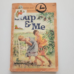 May include: Vintage paperback book titled "Soup & Me" by Robert Newton Peck. The cover features an illustration of two children in a field. The book has a worn, orange cover with the text "A Dell Yearling Book".