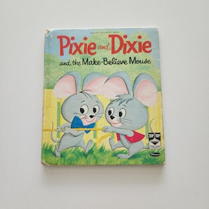 May include: Vintage children's book titled "Pixie and Dixie and the Make-Believe Mouse." The cover features two cartoon mice in blue and red outfits, pulling on a rope. The background is green and yellow.