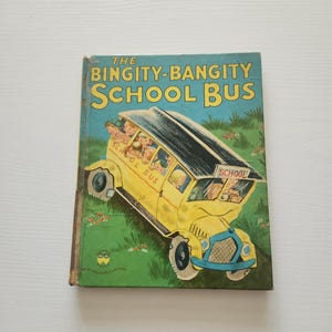 May include: A vintage children's book titled "The Bingity-Bangity School Bus." The cover features a yellow school bus with children inside, set against a green grassy background. The title is in large yellow letters.