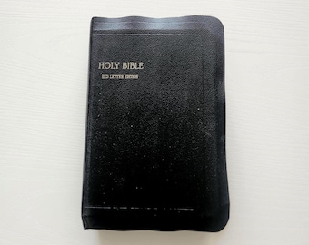 May include: A black Holy Bible with the text "HOLY BIBLE" and "RED LETTER EDITION" in white lettering. The book has a textured cover and is closed.