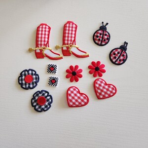 May include: A collection of fabric patches in various shapes and designs. Includes red and white gingham cowboy boots, ladybugs, flowers, hearts, and squares with heart details. The patches are in red, white, black, and gold.